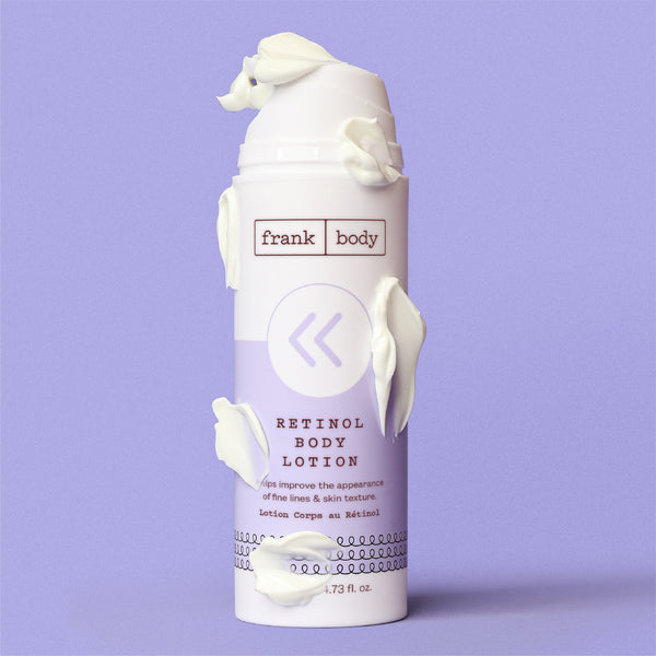 A white pump bottle of Frank Body Retinol Body Lotion with white lotion cream sculpted around it, set against a solid lavender background.