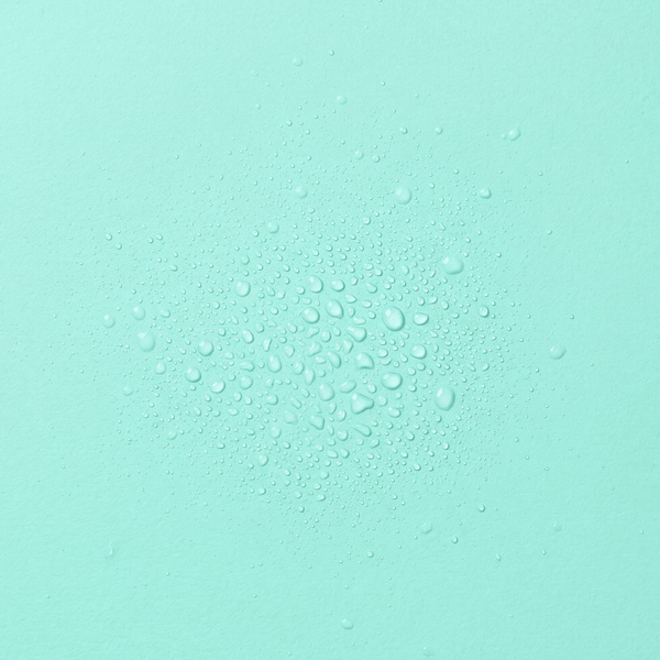 Droplets of frank body Skinny Dip Hair & Body Mist on a mint background.