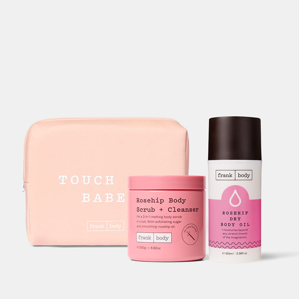 The frank body rosehip duo: a peach pouch with the Rosehip Body Scrub + Cleanser tub and Rosehip Dry Body Oil bottle, on a grey background.